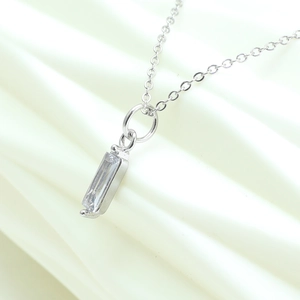 Close-up of minimalist silver chain necklace with rectangular clear zircon stone