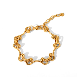Detailed view of golden stainless steel bracelet with wavy links and lobster clasp