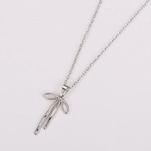 Detail of silver stainless steel bow pendant necklace with high-polished metallic finish