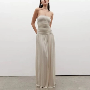Detail of elegant cream strapless maxi dress featuring pleated bodice and flowing skirt