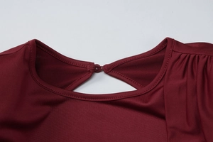 Dettaglio dello scollo posteriore bordeaux con elegante apertura e chiusura a bottone
