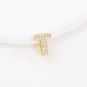 Macro shot of gold bubble letter T pendant with paved sparkling cubic zirconia details