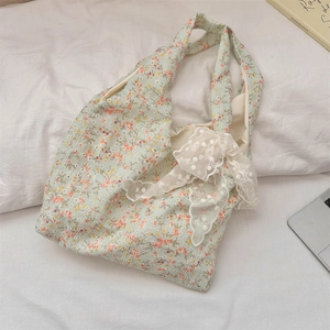 Detail of floral canvas tote bag featuring delicate white lace bow and vintage flower pattern
