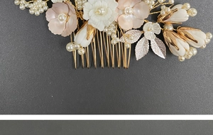 Detail of bridal hair comb with pink ceramic flowers, white pearls and gold leaves