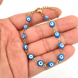 Detail of Turkish Evil Eye bracelet with blue enamel beads and gold-plated chain
