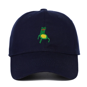 Close-up of a green frog embroidery on the front of a navy blue cotton baseball cap