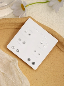 Detail view of 6-pair silver earring set with hearts and stars on a weekly display card