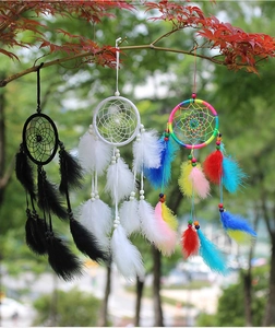 Outdoor close-up of handmade dreamcatchers with natural feathers in black and white