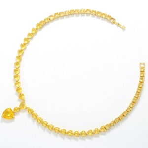 Macro detail of luxury heart necklace with yellow crystals and tennis chain links