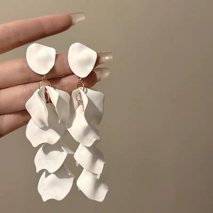 Detailed close-up of handmade white flower petal earrings with pearl and gold metal links