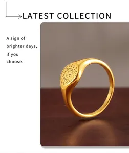 Macro shot of gold sunburst signet ring with small engraved heart on a wooden surface