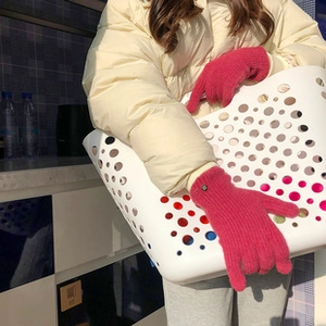 Detalle de guantes de punto rosa fucsia térmicos con función táctil para el frío invierno