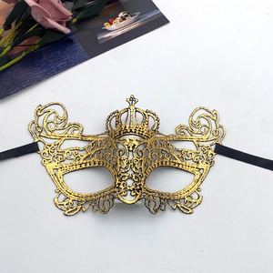 Detail of gold crown lace masquerade mask with intricate hollow patterns and black ribbons