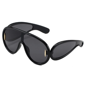 Oversized futuristic shield sunglasses with black frame and gold metal accents