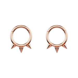 Macro detail of rose gold septum rings featuring symmetric spiked punk design accents