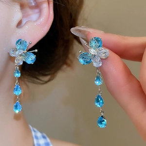 Detail of butterfly tassel earrings with blue zircon water drop pendants in silver finish
