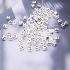 Macro detail of heart-shaped S925 silver spacer beads for DIY jewelry making