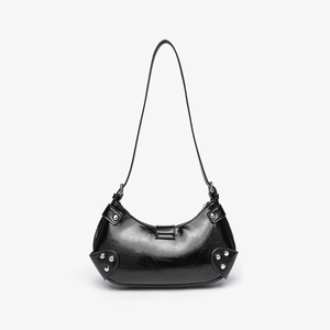 Close-up of black PU leather shoulder bag with silver rivets and glossy croc-effect texture