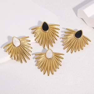Détail de boucles d'oreilles éventail en or 18 carats avec pierres en forme de larme noire et blanche