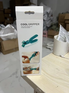 Close-up of retail packaging for a green silicone anti-scald bowl clip and dish gripper