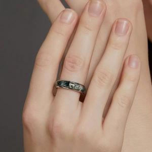 S925 sterling silver ring with moss agate stone shown on a model's hand in macro view