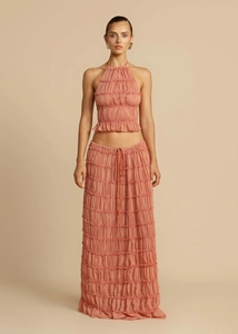Detailed full view of peach tiered maxi skirt and halter crop top set in crinkled fabric