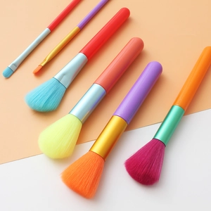 Colorful 6-piece watercolor makeup brush set on a soft pink and white gradient background