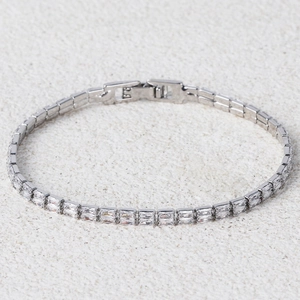 Macro detail of silver tennis bracelet featuring rectangular cut clear zircon stones