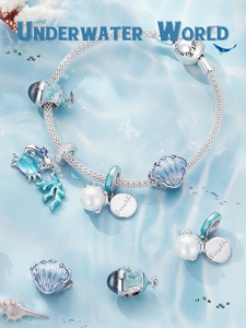 Macro shot of S925 sterling silver ocean charms with blue enamel and pearls