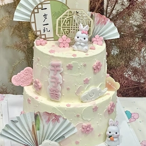 Detail of traditional Chinese rabbit cake topper set with folding fan and wooden tag