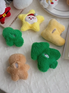 Detail of plush Christmas tree and gingerbread man hair clips on white background
