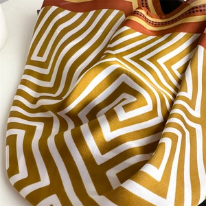 Détail macro du foulard en soie synthétique avec motif labyrinthe géométrique