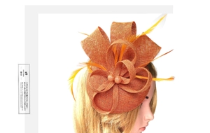 Close-up of orange fascinator hat with elegant mesh layers, feathers and bead details