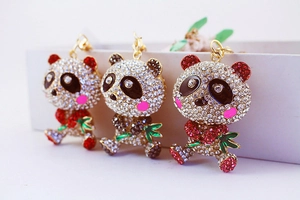 Close-up of diamond-studded panda keychains with green bamboo and metallic finish
