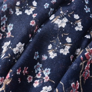 Close-up of navy blue floral cotton scarf fabric with twill texture and soft drape detail
