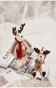Detail view of handcrafted wool felt Christmas reindeer ornaments on vintage paper