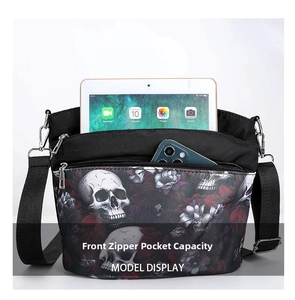Front zipper pocket of gothic skull print bag holding a tablet and smartphone