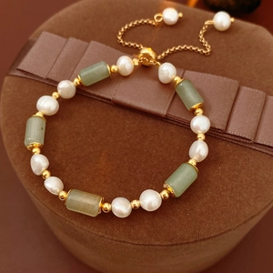 Detail of bamboo-style green jade and white pearl bracelet with gold plating
