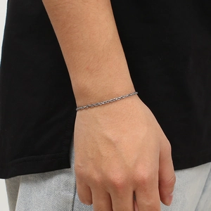 Detail of silver titanium steel rope chain bracelet worn on a female wrist for a chic look
