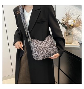 Close-up of leopard print shoulder bag with adjustable wide strap in grey-black tones