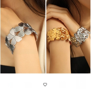Detailed close-up of 18K gold plated wide cuff bracelet with 3D butterfly and flower motifs