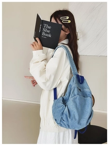 Lifestyle shot of a woman wearing a vintage blue denim backpack in a minimalist setting