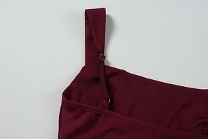 Detail of burgundy dress showing adjustable dual shoulder straps and silver metal buckles