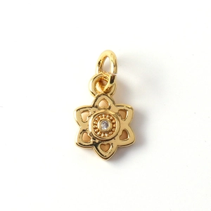 Macro view of gold flower star pendant with clear zircon stone and intricate textures