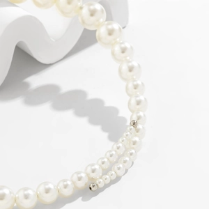 Detail showing gradient layered pearls with silver accents on a minimalist background