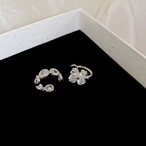Close-up of silver zircon ear cuffs with floral designs on black velvet jewelry box
