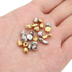Golden and silver irregular stainless steel beads for DIY jewelry making in palm