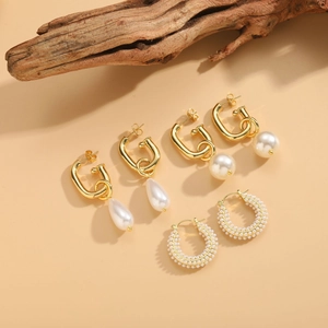 Detailed close-up of three gold-plated pearl earring sets in a French vintage style