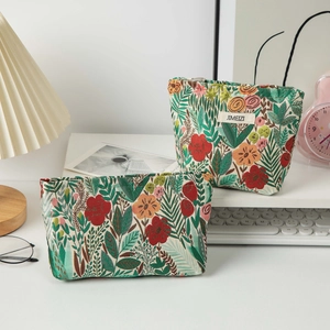 Close-up of floral embroidery on a high-capacity woven fabric travel toiletry bag