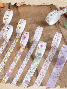 Detailed view of floral washi tape with gold foil accents on a rustic wooden background